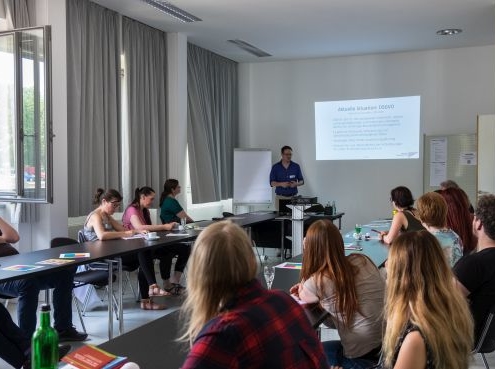 Teilnehmende eines Seminars schauen Richtung Referent